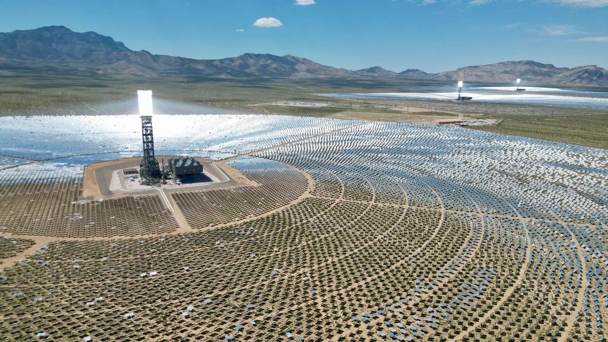 A solar thermal tower rising from its field of mirrors in the Mojave Desert