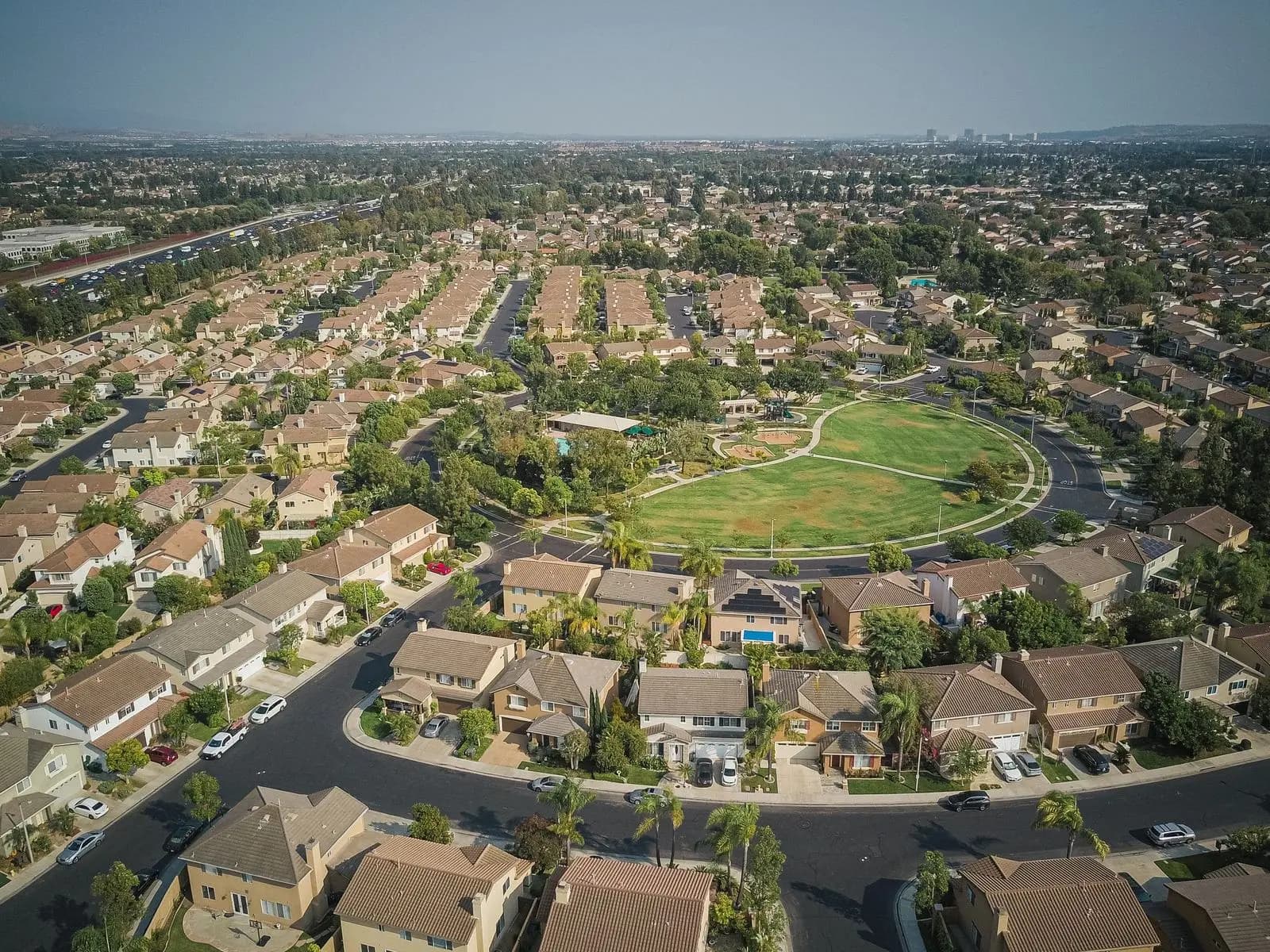 A suburban neighborhood around a central park, seen from the air