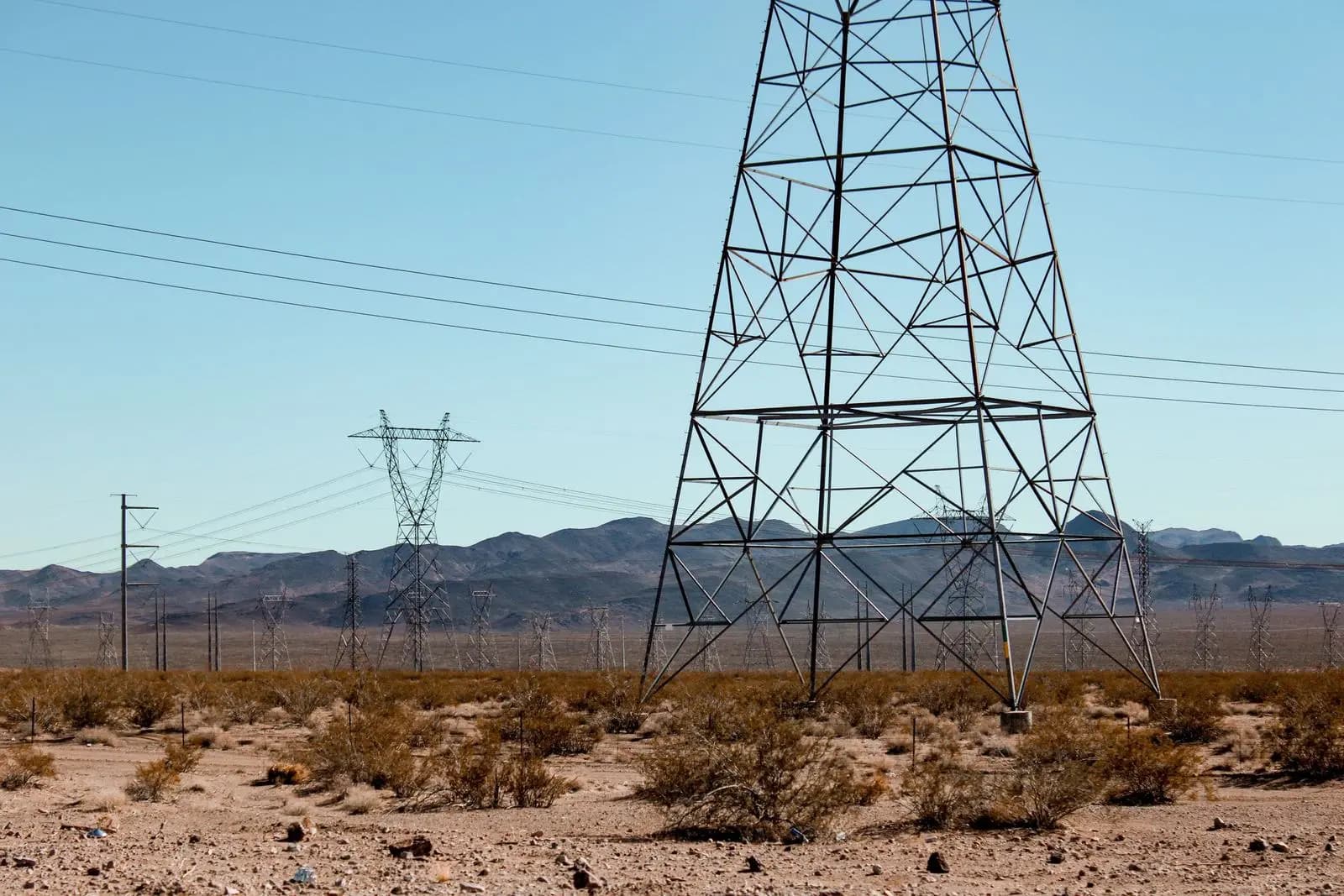 A transmission tower in the Nevada desert with mountains beyond